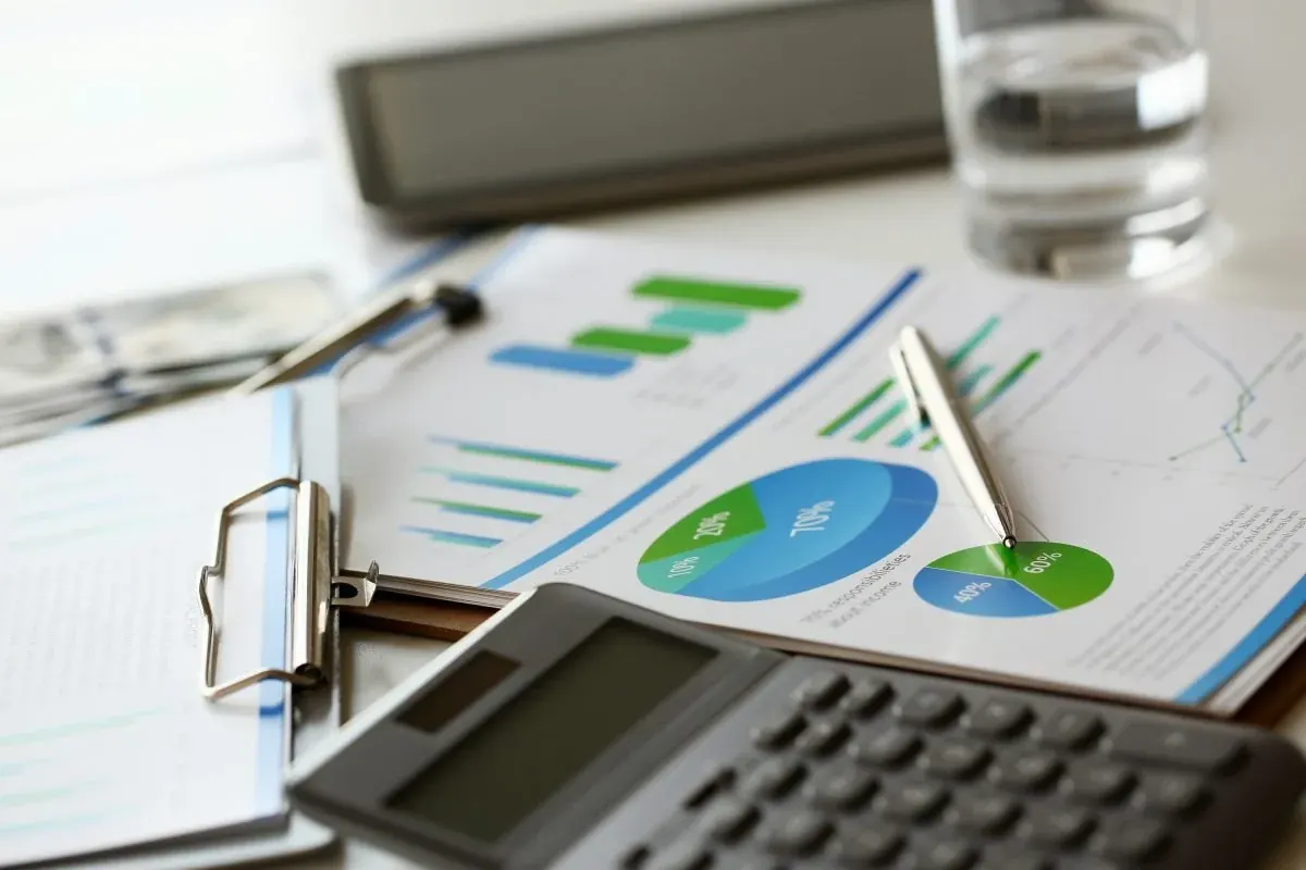 Financial reports, a calculator and a clipboard on a desk